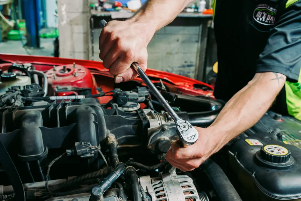 Mechanic performing engine repair on an import vehicle at Al’s D&I Auto Repair in Rapid City, SD.
